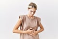 Young blonde woman standing over isolated background with hand on stomach because indigestion, painful illness feeling unwell Royalty Free Stock Photo