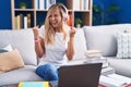 Young blonde woman studying using computer laptop at home very happy and excited doing winner gesture with arms raised, smiling Royalty Free Stock Photo