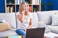 Young blonde woman studying using computer laptop at home yawning tired covering half face, eye and mouth with hand Royalty Free Stock Photo