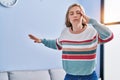 Young blonde woman suffering dizzy standing at home