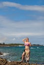 Young blonde woman at summer in bikini at rocky beach