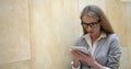 Young blonde woman is surprised and annoyingly answering on the message via the tablet. Close-up portrait.