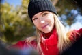 Young blonde woman taking a selfie in a snowy mountain forest in winter. Royalty Free Stock Photo