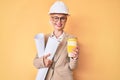 Young blonde woman with tattoo holding paper blueprints drinking take away cup of coffee winking looking at the camera with sexy Royalty Free Stock Photo