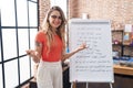 Young blonde woman teacher teaching maths exercise at classroom