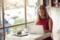 Young blonde woman typing in laptop in cafe Royalty Free Stock Photo