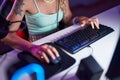 Young blonde woman using computer keyboard and mouse at gaming room Royalty Free Stock Photo