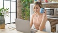 Young blonde woman using laptop drinking coffee at dinning room Royalty Free Stock Photo