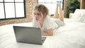 Young blonde woman using laptop lying on bed at bedroom Royalty Free Stock Photo