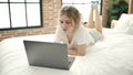 Young blonde woman using laptop lying on bed at bedroom Royalty Free Stock Photo