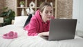 Young blonde woman using laptop lying on bed at bedroom Royalty Free Stock Photo