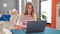 Young blonde woman using laptop with relaxed expression at dinning room Royalty Free Stock Photo