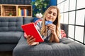 Young blonde woman using touchpad and credit card lying on sofa at home Royalty Free Stock Photo