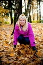 Young blonde woman in violet coat in park