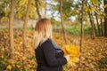 Young blonde woman walking in an autumn park. Fall time Royalty Free Stock Photo