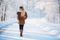 Young blonde woman walking winter park