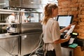 Young woman holding order receipts while working in restaurant kitchen Royalty Free Stock Photo