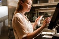 Young woman holding order receipts while working in restaurant kitchen Royalty Free Stock Photo