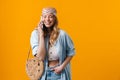 Young blonde woman wearing bandanna smiling and talking on cellphone
