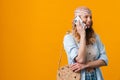 Young blonde woman wearing bandanna smiling and talking on cellphone