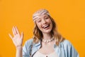 Young blonde woman wearing bandanna smiling and waving hand