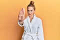 Young blonde woman wearing bathrobe doing stop sing with palm of the hand Royalty Free Stock Photo