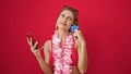 Young blonde woman wearing bikini shopping with smartphone and credit card thinking over isolated red background Royalty Free Stock Photo