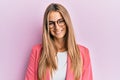 Young blonde woman wearing business style and glasses looking positive and happy standing and smiling with a confident smile Royalty Free Stock Photo