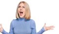 Young blonde woman wearing casual clothes crazy and mad shouting and yelling with aggressive expression and arms raised Royalty Free Stock Photo