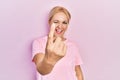 Young blonde woman wearing casual pink t shirt beckoning come here gesture with hand inviting welcoming happy and smiling Royalty Free Stock Photo