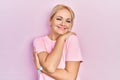 Young blonde woman wearing casual pink t shirt hugging oneself happy and positive, smiling confident Royalty Free Stock Photo