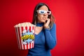 Young blonde woman wearing 3d glasses and eating pack of popcorn watching a movie on cinema looking stressed and nervous with Royalty Free Stock Photo