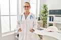 Young blonde woman wearing doctor uniform smiling confident at clinic Royalty Free Stock Photo