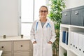 Young blonde woman wearing doctor uniform smiling confident at clinic Royalty Free Stock Photo