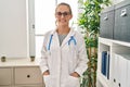 Young blonde woman wearing doctor uniform smiling confident at clinic Royalty Free Stock Photo