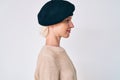 Young blonde woman wearing french look with beret looking to side, relax profile pose with natural face with confident smile Royalty Free Stock Photo