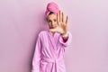 Young blonde woman wearing shower towel cap and bathrobe doing stop sing with palm of the hand Royalty Free Stock Photo