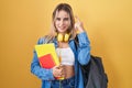 Young blonde woman wearing student backpack and holding books smiling pointing to head with one finger, great idea or thought, Royalty Free Stock Photo