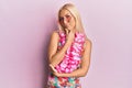 Young blonde woman wearing swimsuit and hawaiian lei serious face thinking about question with hand on chin, thoughtful about Royalty Free Stock Photo
