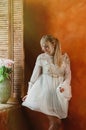 Blonde girl dancing by the window, rose flowers Royalty Free Stock Photo