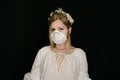 Young blonde woman in white dress and face respirator mask