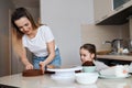 Young blonde woman and her child enjoying cooking desserft for family Royalty Free Stock Photo