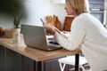 Young blondy woman freelancer at home communicates on smartphone