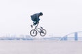 Young BMX bicycle reader does tricks in the air against the background of the urban landscape Royalty Free Stock Photo