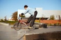 Young bmx biker doing trick, training in skatepark Royalty Free Stock Photo