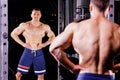 Young bodybuilder with great muscles posing in gym before the mirror Royalty Free Stock Photo