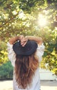 Young boho style woman enjoy sunlight in summer park, hippie, indie style, chic leather black hat, long hair, travel concept, back Royalty Free Stock Photo