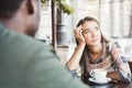 Young bored girl drinking coffee on date at a cafe Royalty Free Stock Photo