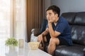 Bored man watching tv and sitting on sofa in the living room Royalty Free Stock Photo