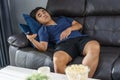 Bored man watching tv and sitting on sofa in the living room Royalty Free Stock Photo